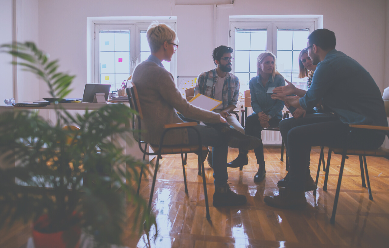 Young people with problems having a discussion while sitting together on special group therapy.